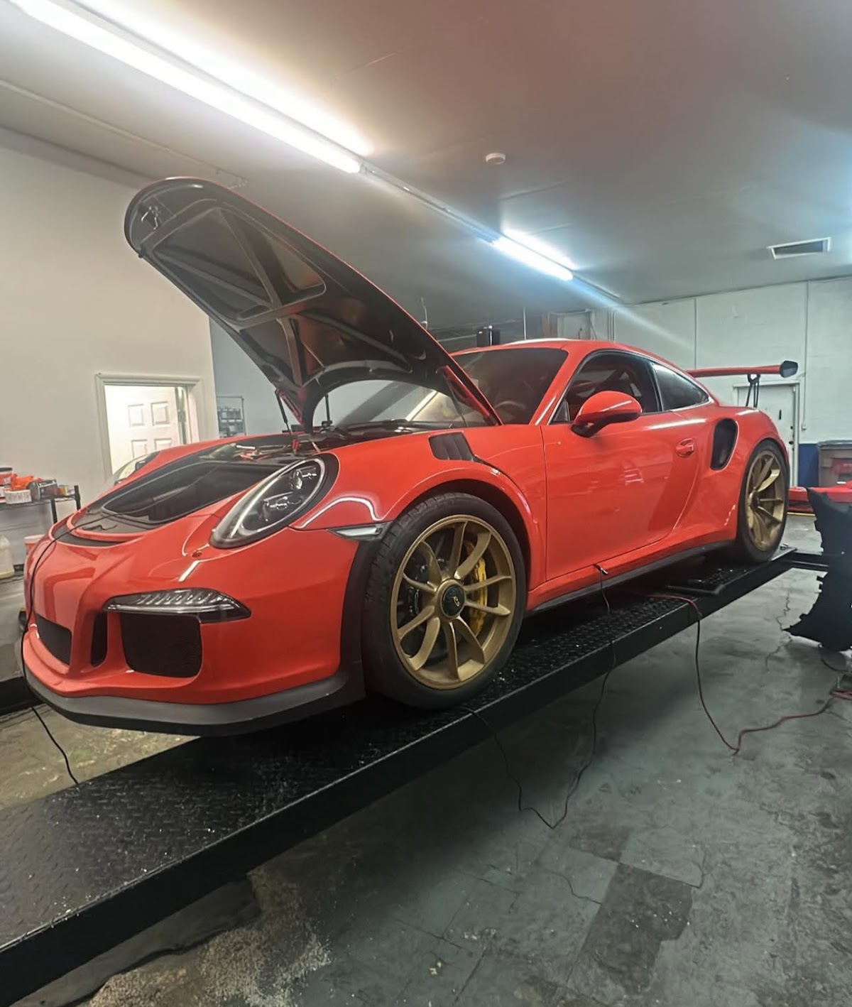 Red Porsche GT3 RS on lift